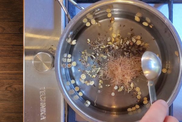 Pot with tonic herbs on stovetop.